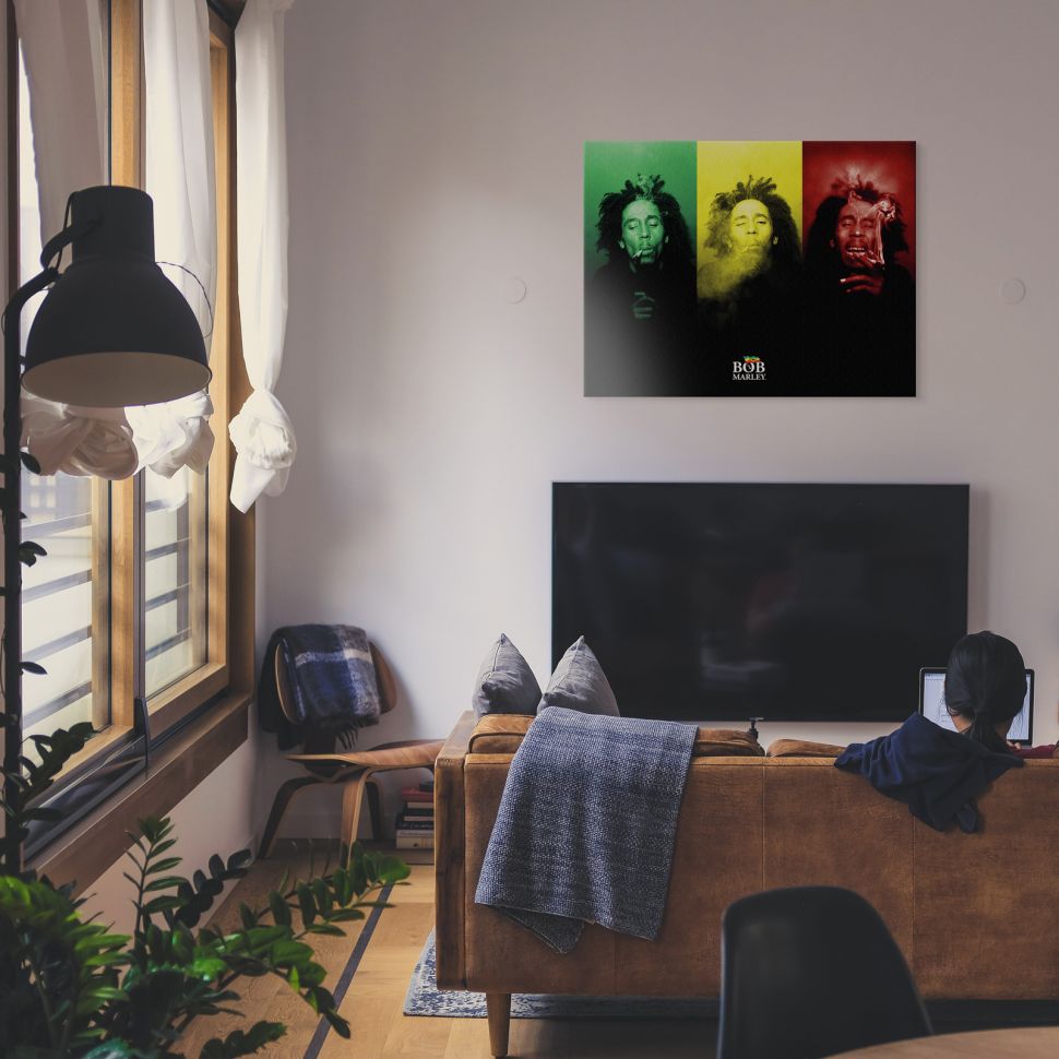 Obraz z palącym Bobem Marley'em w kolorach reggae powieszony w salonie nad telewizorem
