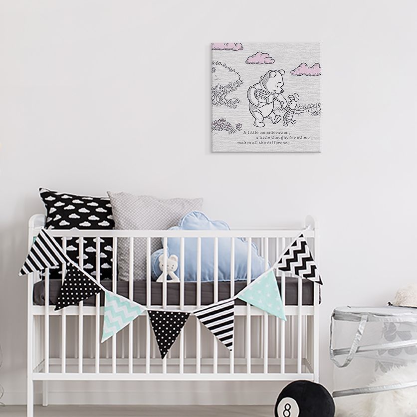 Obraz z Kubusiem Puchatkiem i Prosiaczkiem zawieszony w pokoju dziecka nad łóżeczkiem z poduszkami z motywem chmur