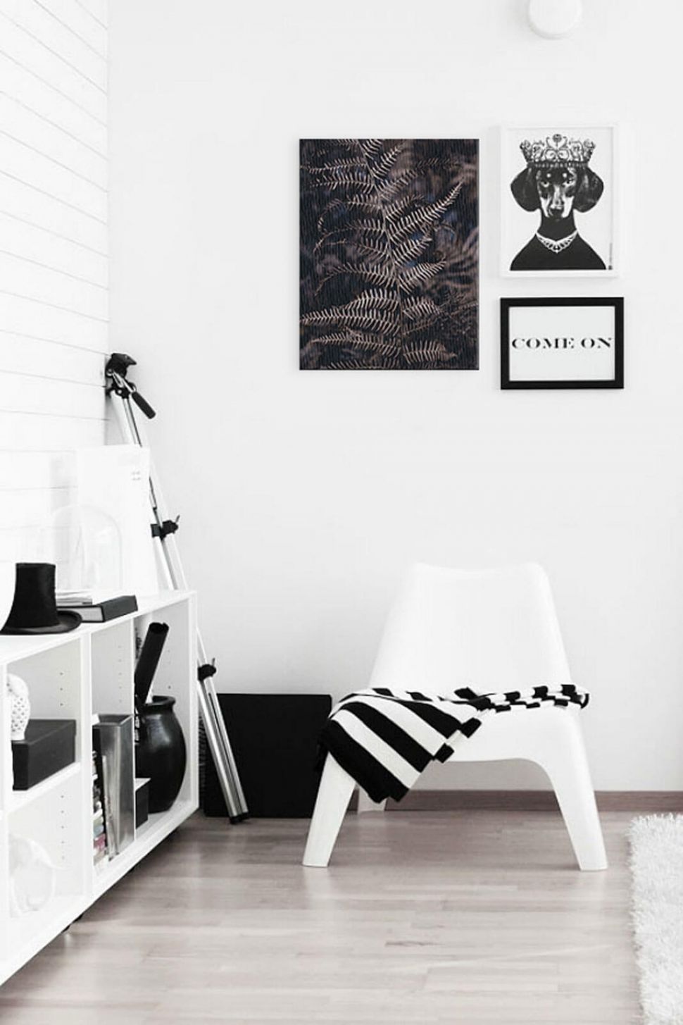 Obraz na płótnie z liściem paproci powieszony w pokoju nad białym fotelem