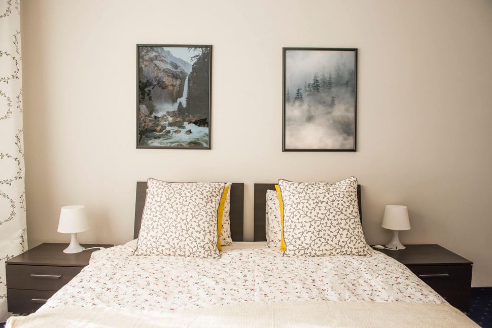 Plakat z wodospadem w górach powieszony w sypialni nad łóżkiem
