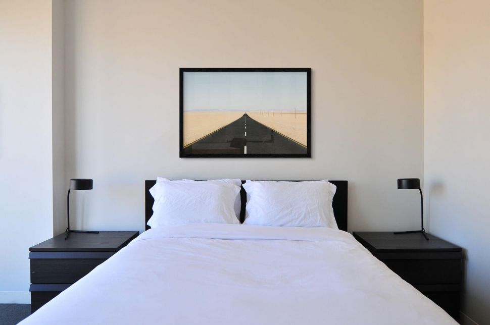 Plakat o nazwie Długa Droga powieszony w sypialni nad łóżkiem