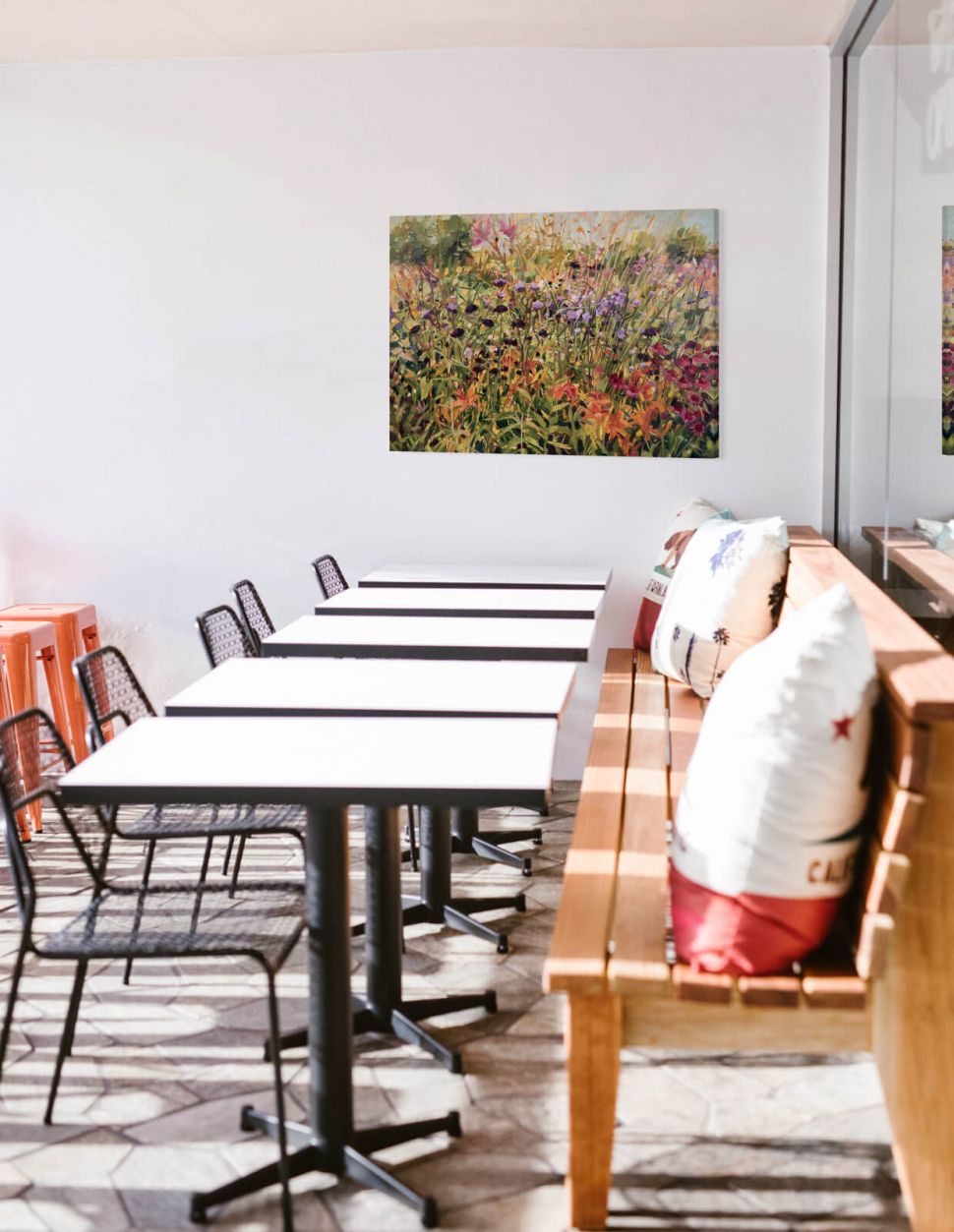 Canvas Field with Lillies przedstawiający kwiecistą łąkę powieszony w kawiarni