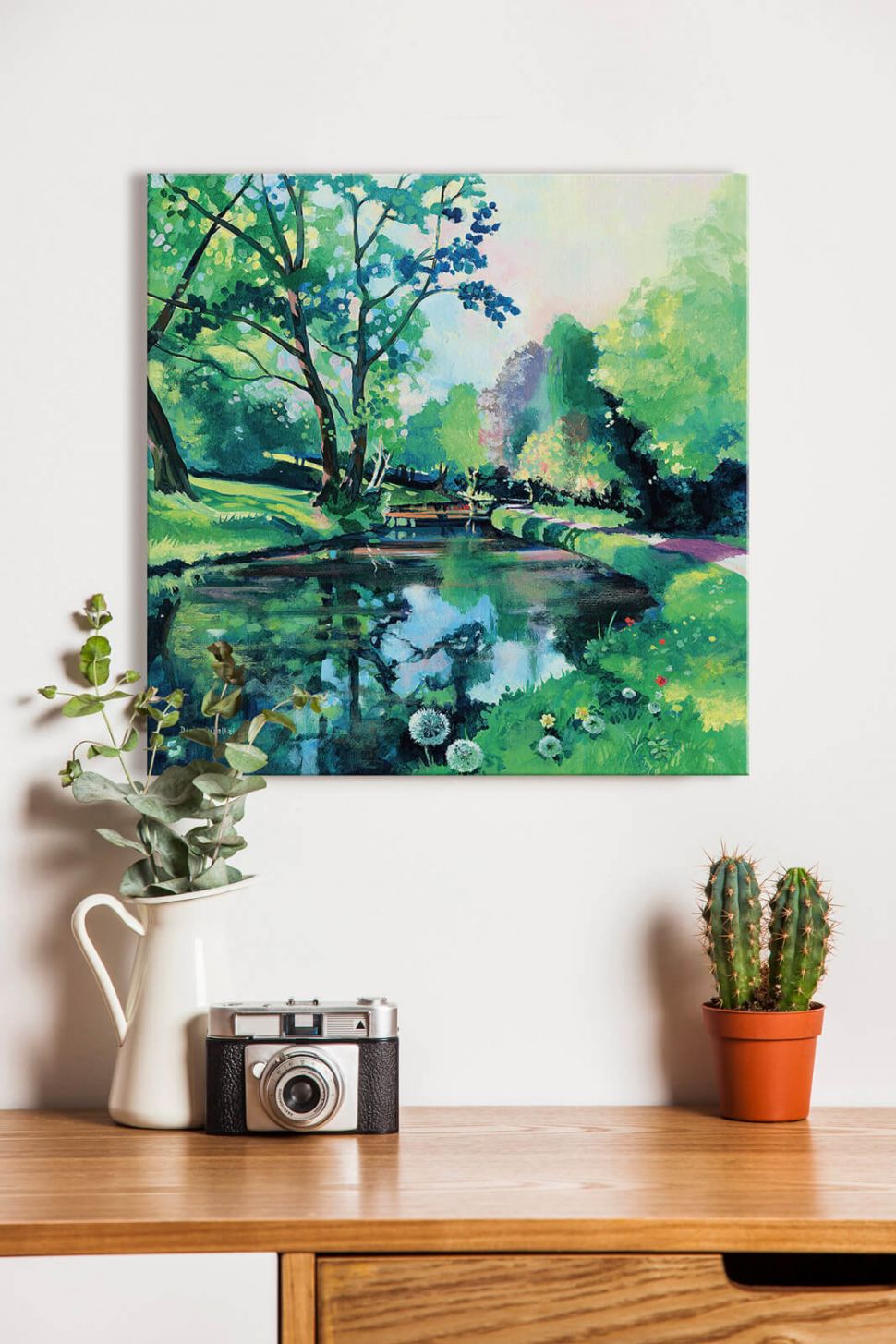 Canvas Riverbank Reflections na ścianie w pokoju nad biurkiem z aparatem i kaktusem