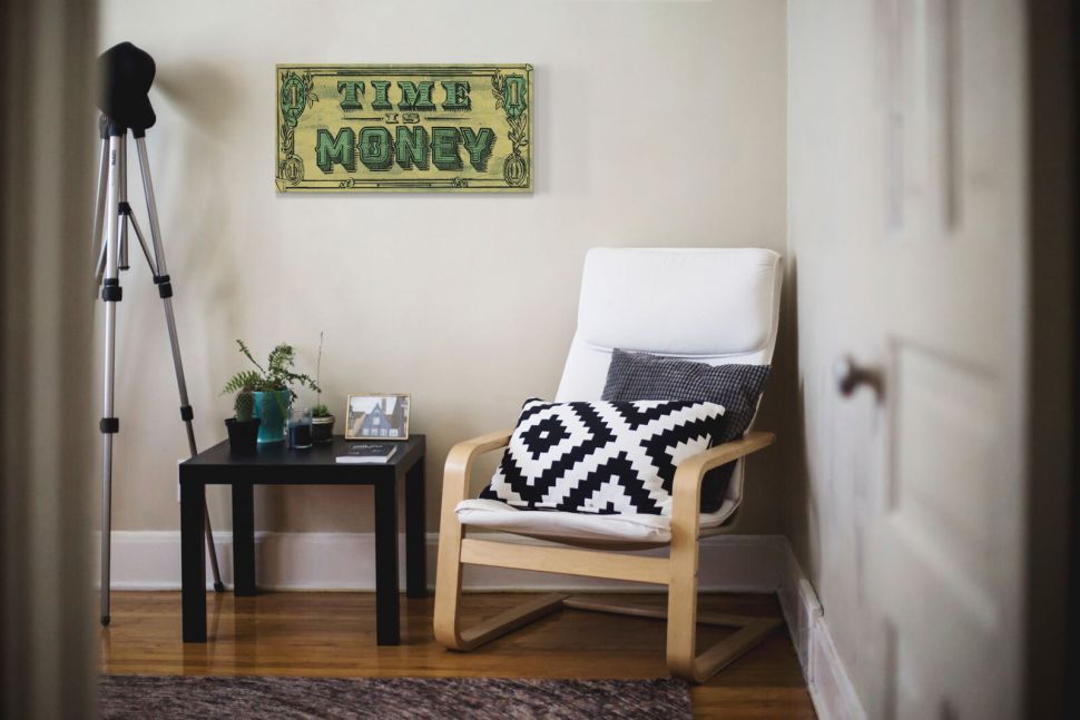 Obraz na płótnie Time Is Money na ścianie w pokoju nad stolikiem i fotelem