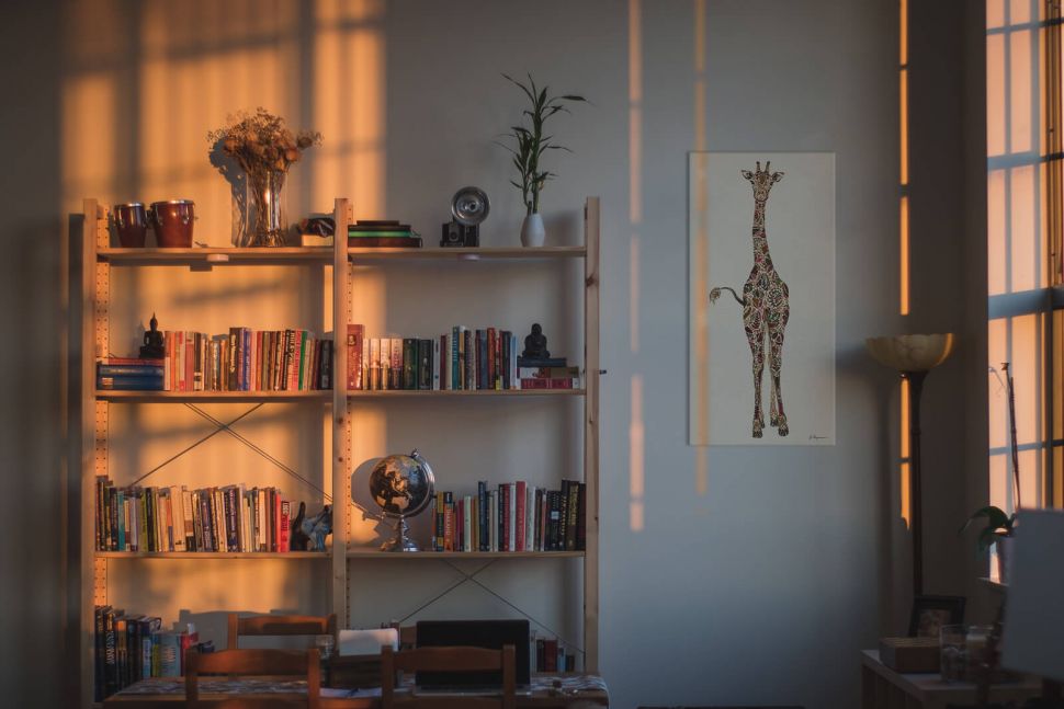 Obraz na płótnie Peering Giraffe na ścianie w pokoju dziecka obok szafki z książkami