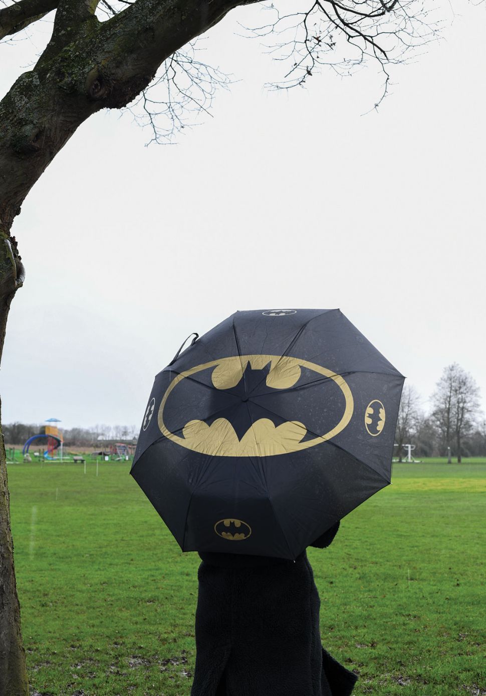 Logo nietoperza na czarnej filmowej parasolce w parku