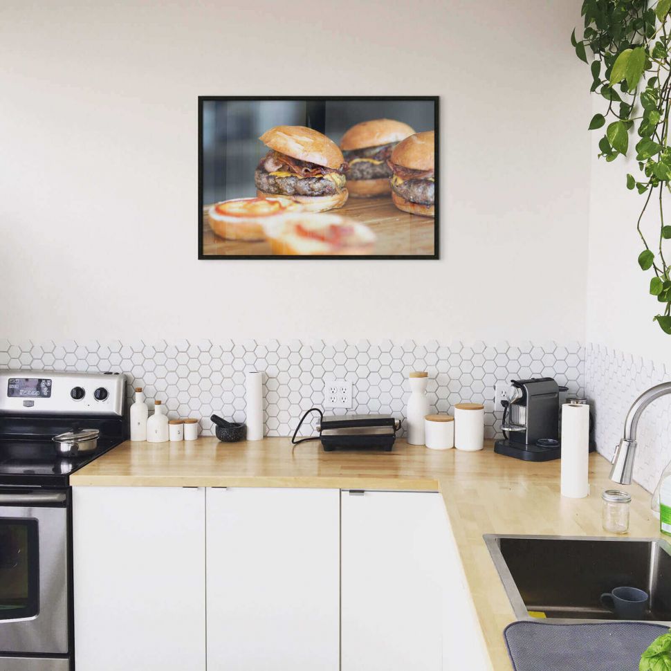 Plakat z burgerami powieszony w kuchni nad blatem