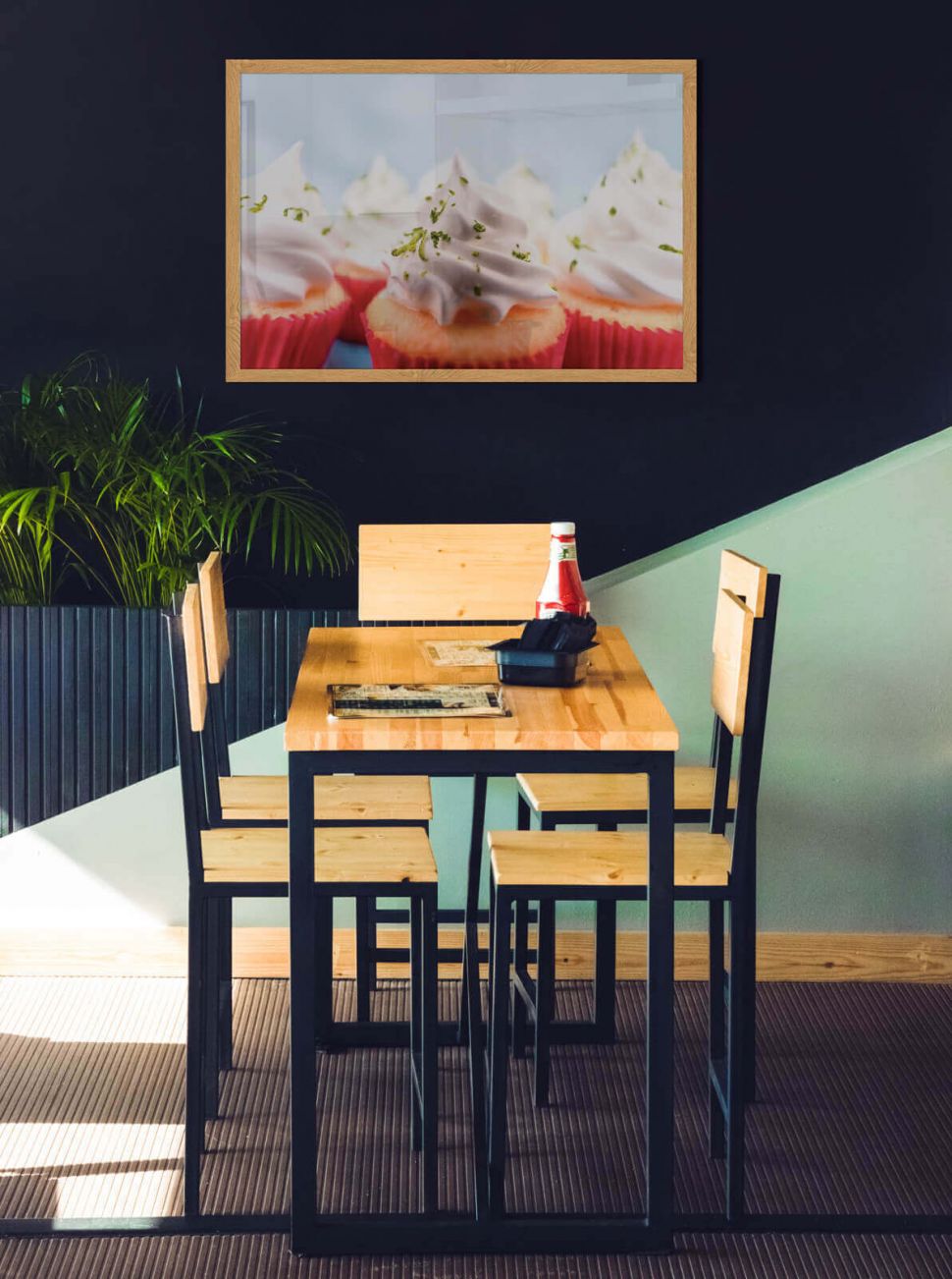 Plakat z babeczkami powieszony w jadalni nad stołem