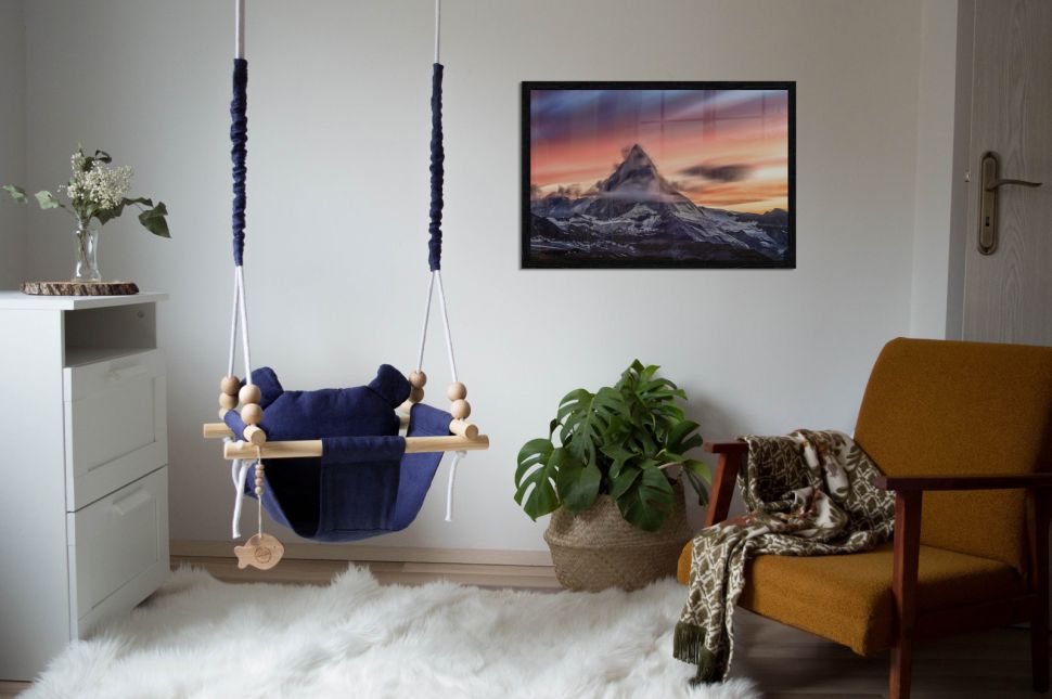 Plakat z górą Matterhorn powieszony w salonie na białej ścianie