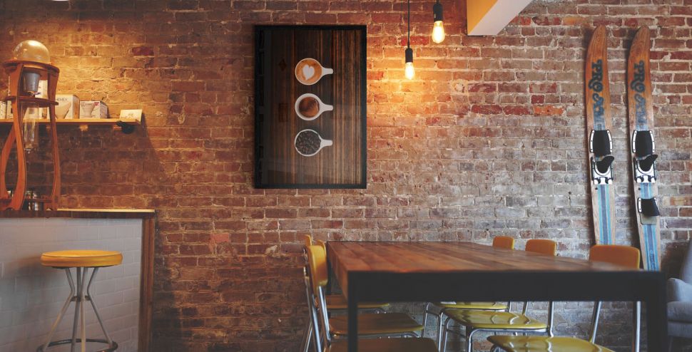 Plakat Kawa w 3 krokach powieszony w barze na ścianie z cegły