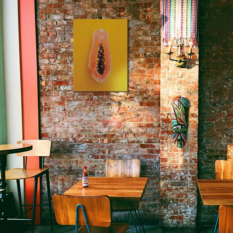 Obraz na płótnie Papaja powieszony w kawiarni nad stolikiem