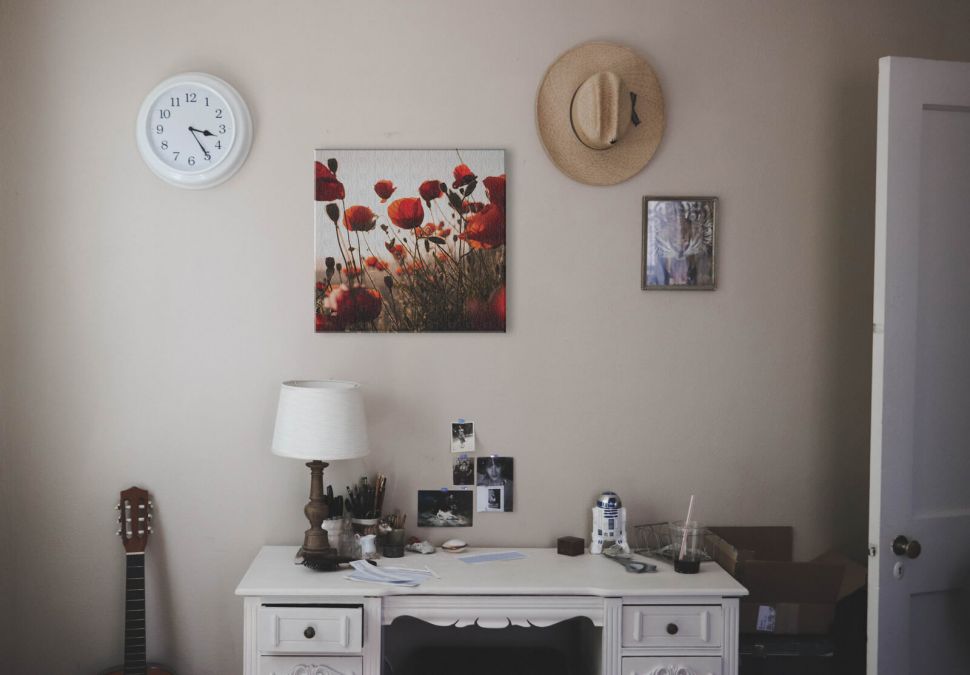 Obraz z łąką czerwonych maków powieszony w pokoju nad białym biurkiem