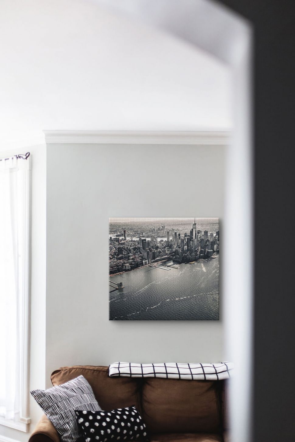 Obraz na płótnie z panoramą Nowego Jorku powieszony nad brązową kanapą