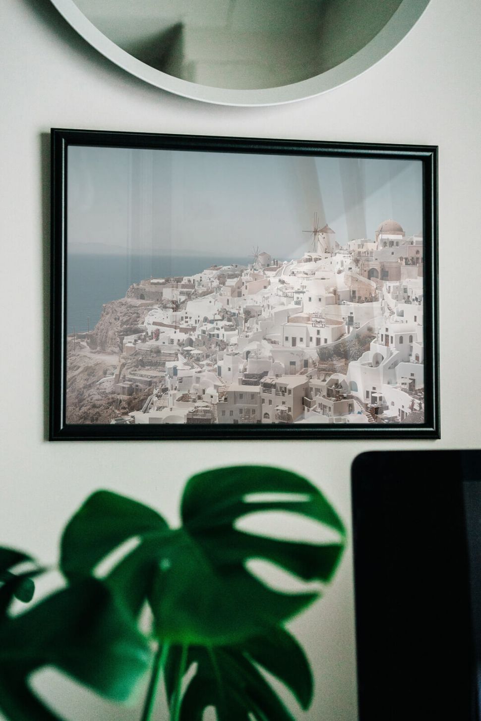Plakat z Santorini w czarnej ramie powieszony na białej ścianie