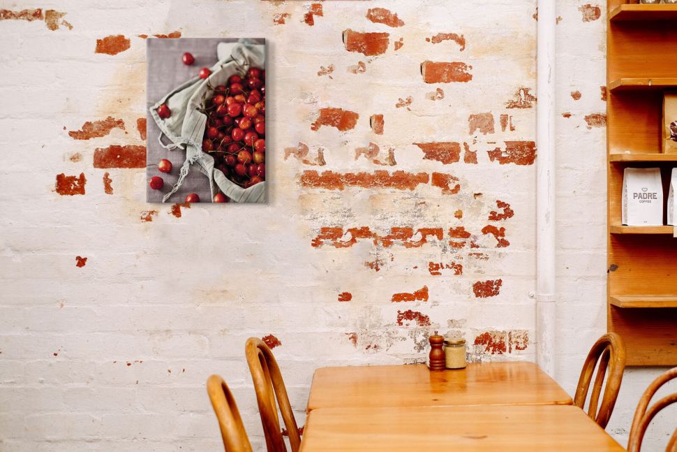 Canvas Kosz pełen wiśni powieszony w kawiarni na ścianie nad stolikiem
