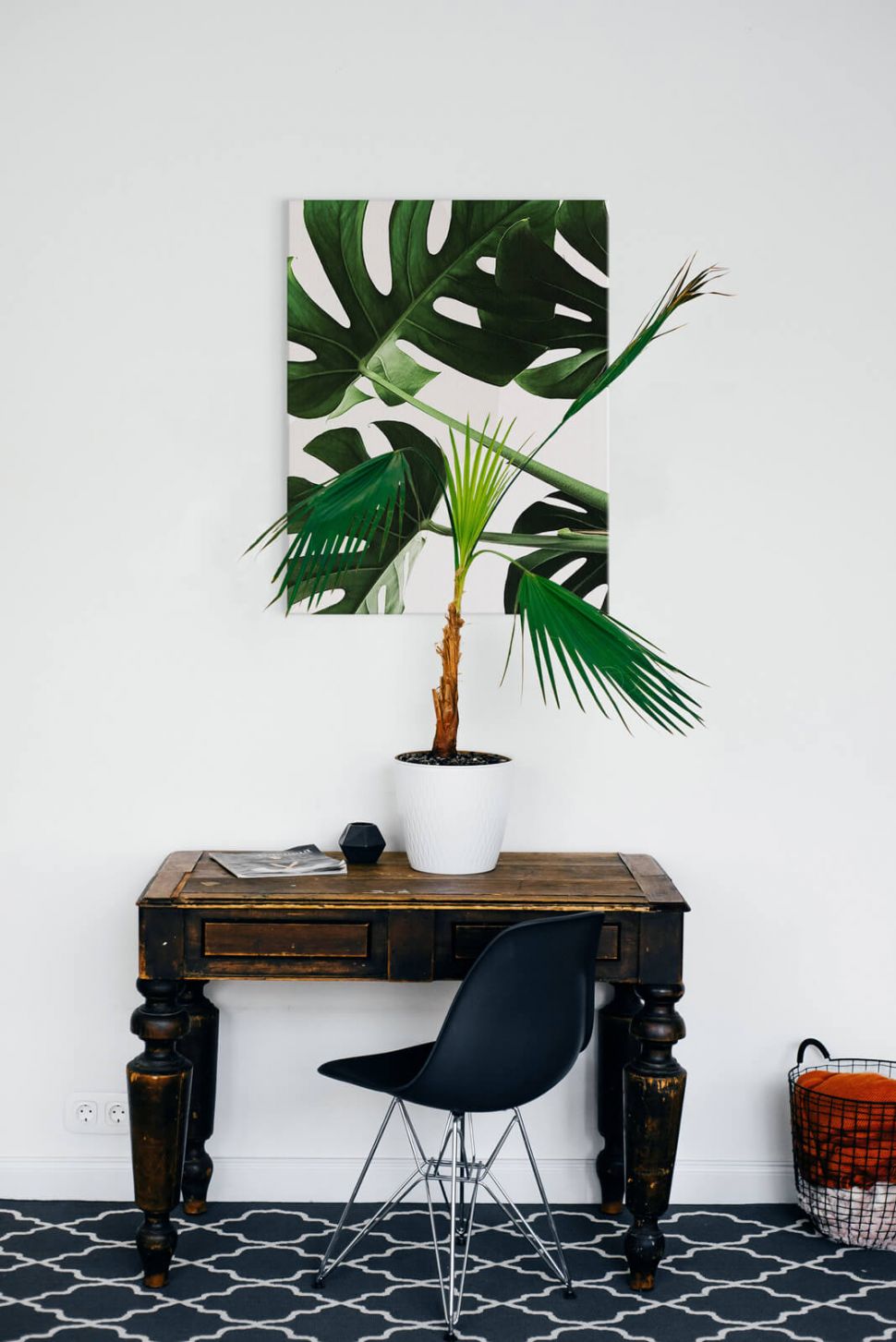 Obraz płócienny Egzotyczne liście powieszony nad stolikiem na białej ścianie