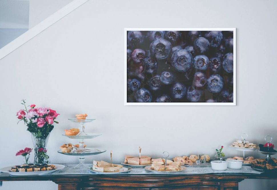 Plakat z jagodami w kuchni nad zastawionym stołem