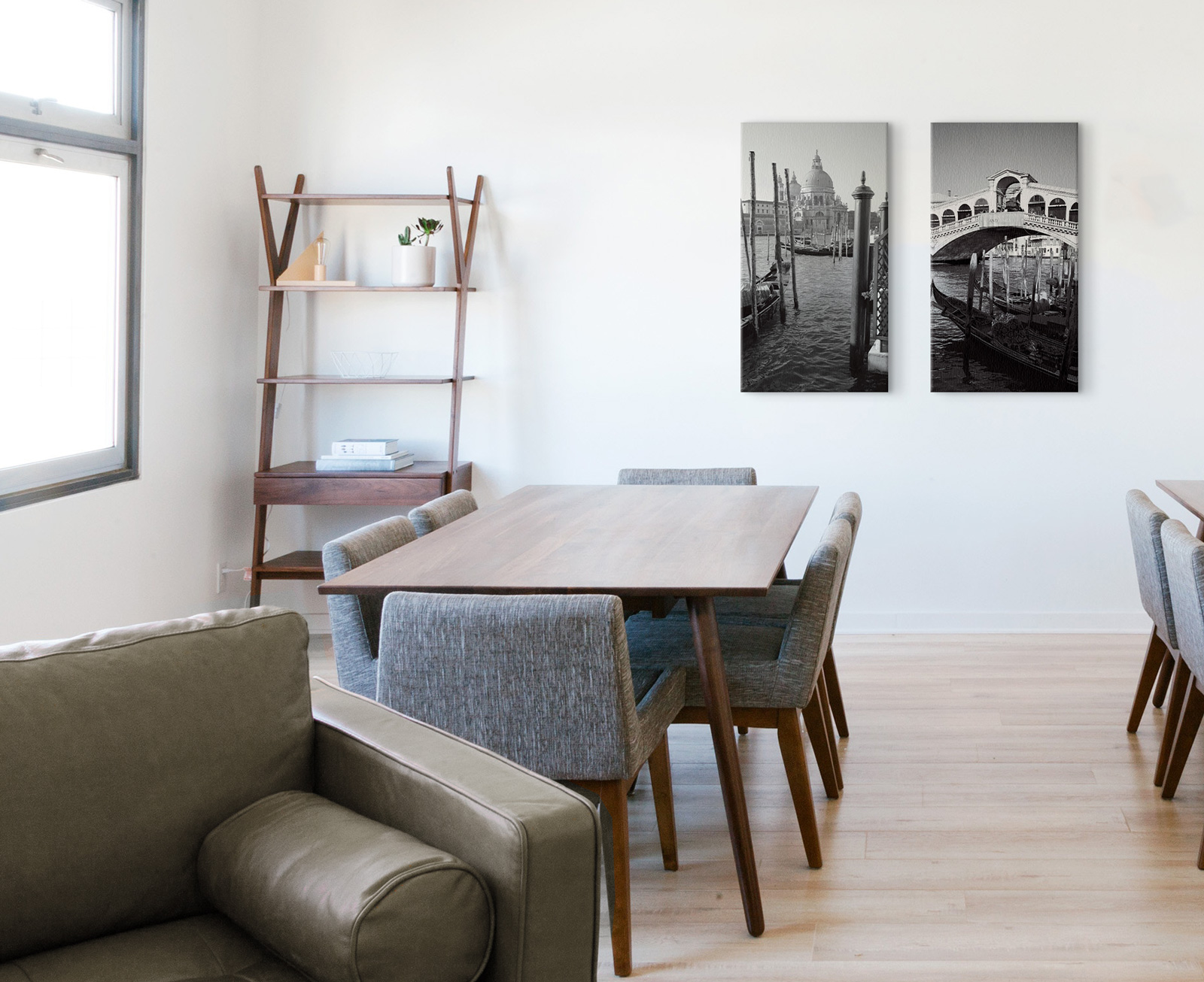 Czarno-białe obrazy weneckich zabytków w salonie nad stołem