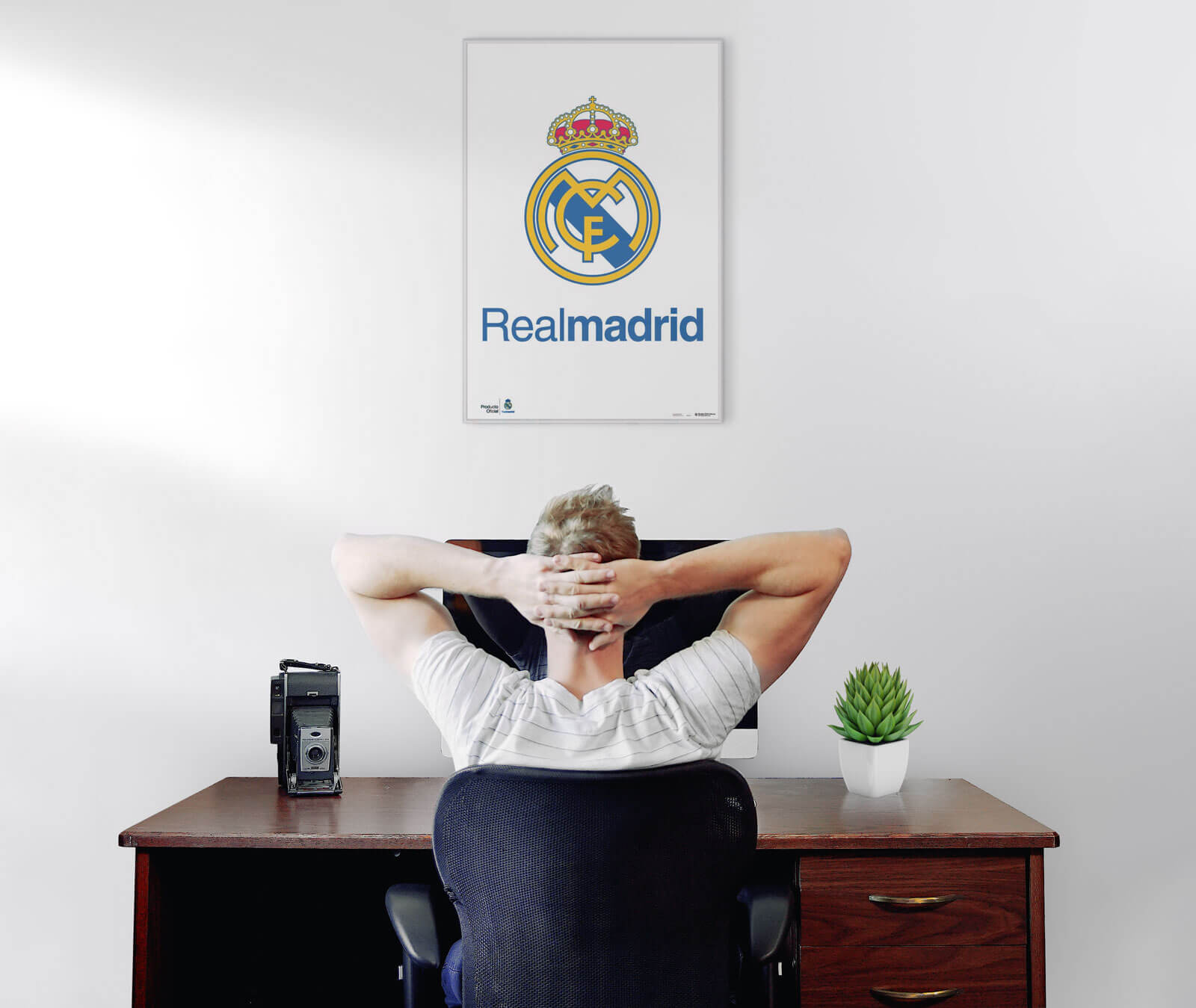 Plakat z logo Realu Madryt powieszony nad biurkiem